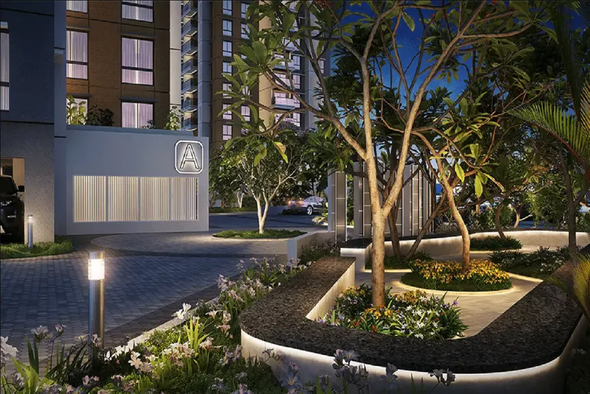Night view of Purva Esplanade showing landscaped gardens, illuminated pathways, and modern residential towers in the background with soft architectural lighting